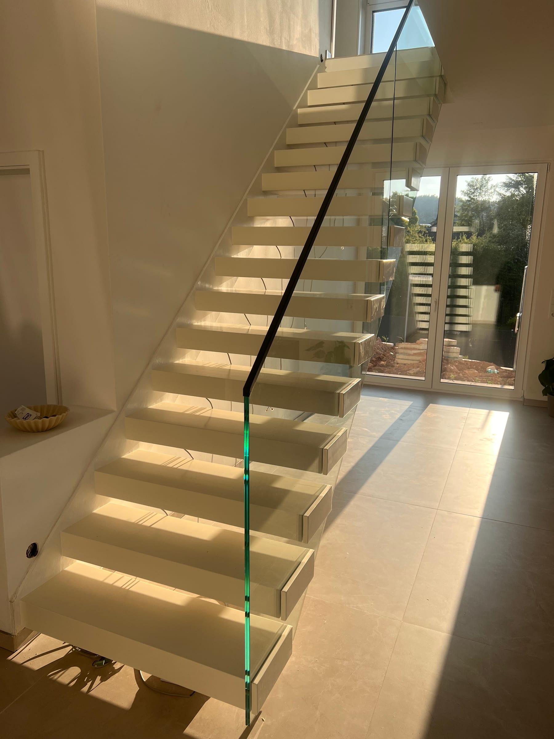 Kragarmtreppe mit Glasbrüstung im lichtdurchfluteten Treppenhaus